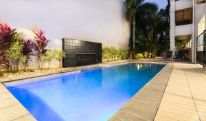 a swimming pool with a television in front of it at Cairns City Apartments in Cairns