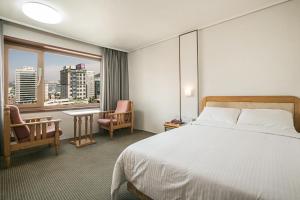 Postel nebo postele na pokoji v ubytování Busan Tourist Hotel