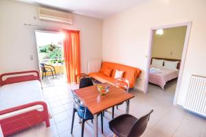 a room with a bed and a table and a bedroom at Voula Apartments in Mytikas