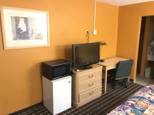 a hotel room with a desk and a tv and a bed at Spring Valley Inn in Spring Valley