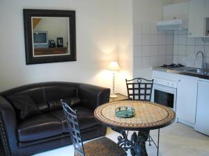 a living room with a couch and a table at Résidence Hôtelière La Marine in Combleux