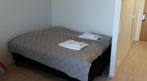 a bed with two towels sitting on top of it at MR Apartments in Vaasa