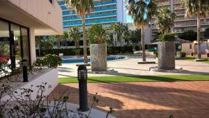 a courtyard with palm trees and a building at coral beach in Calpe