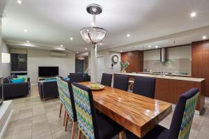 a dining room and kitchen with a wooden table and chairs at The Bay Residence, Dunsborough WA in Quindalup