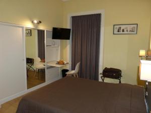 Cette chambre comprend un lit, un bureau et une table. dans l'établissement Hôtel Terminus, à Nantes