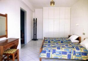 a bedroom with a bed and a desk in it at Eleni Palace in Amoudara Herakliou