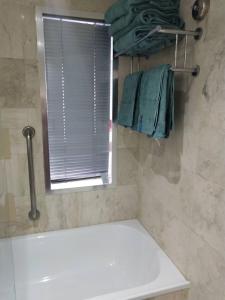 a bathroom with a tub and a window and towels at High Floor Ocean View at Surfers Paradise - Hotel Studio in Gold Coast +20 photos