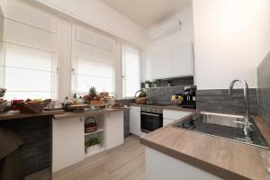 una cocina con armarios blancos y fregadero en Taranta Suite en Lecce