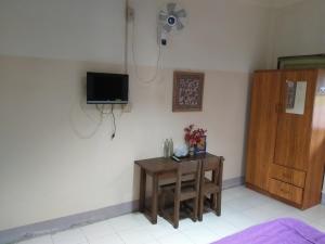 a room with a table and a tv on a wall at Tanyahouse in Chiang Rai