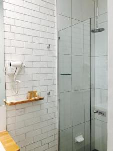 a glass shower in a bathroom with white walls at Gin Gin Village Motor Inn Motel QLD in Gin Gin