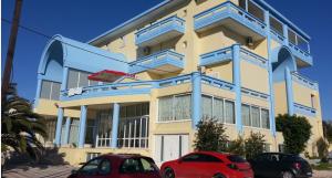 a building with two cars parked in front of it at Eleni Palace in Amoudara Herakliou