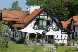 uma casa com guarda-chuvas brancos em frente em Szwajcaria Mazurska em Zawady