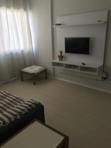 sala de estar con TV de pantalla plana en la pared en Apart Príncipe Barra, en Salvador