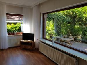 a living room with a large window and a table at Hanse Hotel Buxtehude in Buxtehude