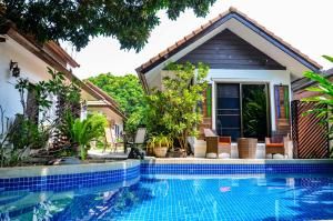 a house with a swimming pool in front of a house at Rice Barn And Rooms in Hang Dong