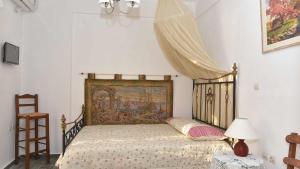 a bedroom with a bed with a tapestry on it at Anemos and Almyra in Kinion