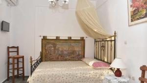 una camera da letto con un letto con un arazzo sopra di Anemos and Almyra a Kinion