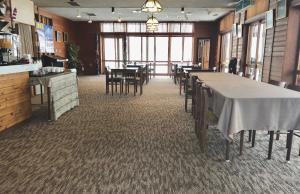 a dining room with tables and chairs in a restaurant at Hakuba Landmark Happo Lodge in Hakuba