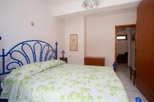 1 dormitorio con 1 cama con colcha verde y blanca en La Bitta, en Lipari