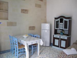 y cocina con mesa, sillas y nevera. en Otranto Vacanza Facile - Via San Francesco Da Paola, en Otranto