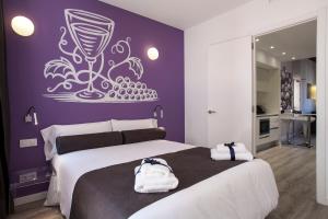 Dormitorio con cama grande y copa de vino en la pared en Habitat Apartments ADN, en Barcelona
