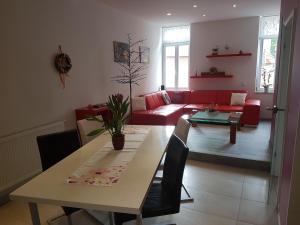 a living room with a table and a red couch at ZUM LÖWE in Waltershausen