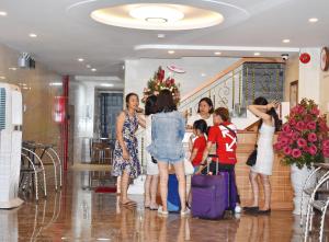 a group of people standing in a lobby with luggage at Danang Beach Homestay in Danang
