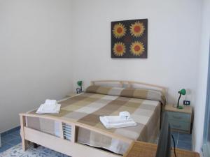 1 dormitorio con 1 cama con mesa y una foto en la pared en Otranto Vacanza Facile - Via San Francesco Da Paola, en Otranto