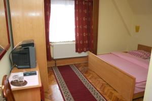 a small bedroom with a bed and a television at Guest House Prepelica in Prelog