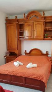two white towels on a bed with wooden cabinets at Apartments Damjanic Jerko in Vrboska