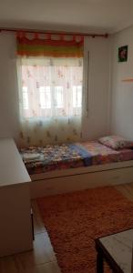 a bedroom with a bed with a window and a rug at Beach Villa Grande in Santiago de la Ribera
