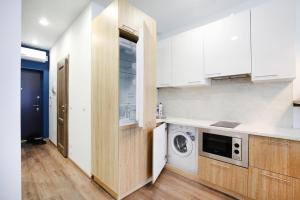 エカテリンブルクにあるApartments "Rooms" in Radiusのキッチン(白いキャビネット、洗濯機付)