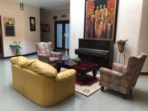a living room with two chairs and a piano at Lido Hotel in Johannesburg