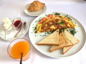 a plate of breakfast food with toast and orange juice at Sofievsky Posad Hotel in Kyiv