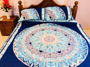 a bed with a blue and white comforter on it at Northwood Residence - Marawila in Marawila