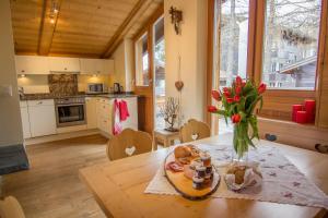 a kitchen with a table with a vase of flowers on it at Chalet Greta in Saas-Fee