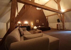 ein Wohnzimmer mit einem Sofa und einem Bett in der Unterkunft Hotel The Lodge Heverlee in Löwen