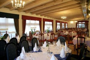 a dining room with tables and chairs and chandeliers at Guest House Prepelica in Prelog