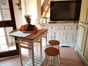 a kitchen with a table with a pineapple and two stools at Il Cortile di Dea in Arzachena