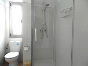 a bathroom with a toilet and a glass shower at Apt. Eros in Conil de la Frontera