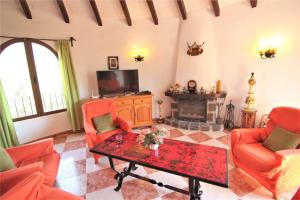 a living room with orange chairs and a table and a tv at MARYVILLA 231 in Calpe