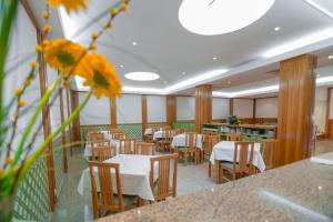 um restaurante com mesas e cadeiras de madeira e uma flor em Hotel Peregrinos de Fatima em Fátima