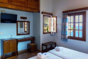 a room with two beds and a tv and a window at Drymna in Trizonia