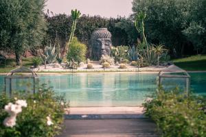 une grande statue dans un jardin à côté d'une piscine dans l'établissement Villa Imperiale, à Marrakech