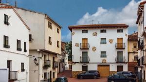 a city street with two buildings and cars parked at Alojamiento Rural La Gerencia - Casa Evelia in Checa +13 photos