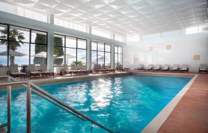 a pool in a hotel with tables and chairs at Hotel Kristal - Liburnia in Opatija