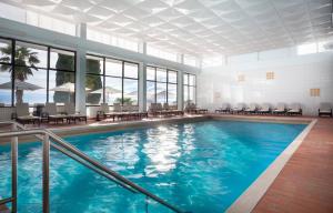 una piscina en un hotel con mesas y sillas en Hotel Kristal - Liburnia, en Opatija
