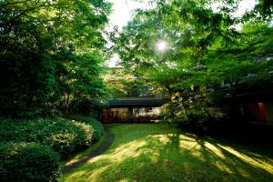 uitzicht op een tuin met bomen en een gebouw bij Ranzan in Kyoto