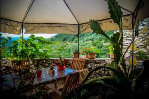 un patio con mesa, sillas y plantas en Bed & Breakfast Ca' di Vissai, en Arnasco