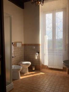a bathroom with a toilet and a sink and a window at Casa Vacanze La Torretta in Sutri +12 photos